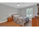Comfortable bedroom with a patterned quilt, hardwood floors, and a window with shutter blinds at 605 Macglenross Dr, Oviedo, FL 32765