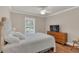 Bright bedroom with a large window, white bedding, hardwood floors and modern dresser with TV at 605 Macglenross Dr, Oviedo, FL 32765