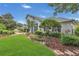 Landscaped front yard features mature trees, lush plants, and a winding stone pathway to the house at 605 Macglenross Dr, Oviedo, FL 32765
