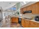 Well-lit kitchen with wood cabinets, tiled backsplash, and modern appliances, adjoined to a dining area at 605 Macglenross Dr, Oviedo, FL 32765