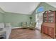 Living area with two arm chairs, wood floors, shuttered window and traditional furnishings at 605 Macglenross Dr, Oviedo, FL 32765