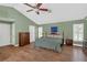 Spacious bedroom with a ceiling fan, hardwood floors, and generous natural light from shuttered windows at 605 Macglenross Dr, Oviedo, FL 32765