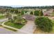 Aerial view of a residential property with lush landscaping, a long driveway, and a well-maintained lawn at 611 Curly Fern Ln, Deland, FL 32720