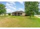 Spacious backyard with lush green lawn, mature trees, and a screened-in porch at 611 Curly Fern Ln, Deland, FL 32720