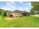 Expansive backyard featuring a well-maintained lawn, mature landscaping, and a screened porch at 611 Curly Fern Ln, Deland, FL 32720