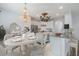 Open concept dining room with modern chandelier, view to kitchen with stainless steel appliances at 611 Curly Fern Ln, Deland, FL 32720