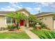 Charming single-story home featuring a red door, a fountain, and a well-manicured lawn at 611 Curly Fern Ln, Deland, FL 32720