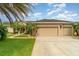 Charming single-story home featuring a fountain, a well-manicured lawn, and an attached two-car garage at 611 Curly Fern Ln, Deland, FL 32720