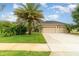 Charming single-story home featuring a fountain, a well-manicured lawn, and an attached two-car garage at 611 Curly Fern Ln, Deland, FL 32720