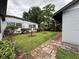 Green backyard with lush landscaping and a brick pathway at 6615 Beamer Way, Orlando, FL 32807
