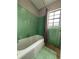 Bathroom with a green tiled shower, a window providing light, and modern fixtures at 6615 Beamer Way, Orlando, FL 32807