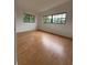 Bedroom featuring hardwood floors and natural light from two windows provides a versatile and inviting space at 6615 Beamer Way, Orlando, FL 32807