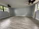 Large living room featuring wood-look tile floor, ceiling fans, and plenty of natural light at 6615 Beamer Way, Orlando, FL 32807
