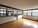 Enclosed sunroom with hardwood floors, large windows, and a glass door at 6615 Beamer Way, Orlando, FL 32807