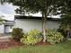 Landscaped side yard, highlighting green grass and mature trees, offering an appealing outdoor space at 6615 Beamer Way, Orlando, FL 32807
