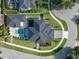 Aerial view of a luxurious home with a dark roof, a pool, and landscaping at 734 Terra Pl, Maitland, FL 32751