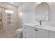 Bright bathroom features a modern vanity, an elegant arched mirror, and a beautiful tiled shower with gold fixtures at 734 Terra Pl, Maitland, FL 32751