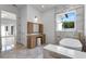 Bright bathroom with a makeup vanity next to a soaking tub under a window, creating a spa-like experience at 734 Terra Pl, Maitland, FL 32751