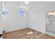 Minimalist bedroom featuring light wood floors, white walls, and two windows, offering a bright and airy feel at 734 Terra Pl, Maitland, FL 32751