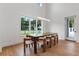 Elegant dining area featuring hardwood floors, a modern light fixture, and expansive windows with lush views at 734 Terra Pl, Maitland, FL 32751