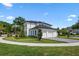 Side view of elegant modern home with a three-car garage, green lawn and beautifully landscaped garden at 734 Terra Pl, Maitland, FL 32751