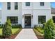 Close-up of modern home's entrance with elegant black door, stylish lighting, and professionally landscaped garden at 734 Terra Pl, Maitland, FL 32751