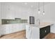 Modern kitchen features white cabinets, an island with a marble countertop, pendant lights and stainless steel appliances at 734 Terra Pl, Maitland, FL 32751