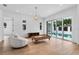 Bright living room featuring hardwood floors, modern furniture, and sliding glass doors to the pool area at 734 Terra Pl, Maitland, FL 32751