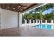 Covered outdoor patio with travertine pavers offers views of the sparkling swimming pool and lush backyard at 734 Terra Pl, Maitland, FL 32751