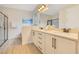 Bright bathroom featuring dual sinks, a quartz countertop, and a walk-in shower with glass door at 7647 Fairfax Dr, Kissimmee, FL 34747