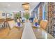 Chic dining room with a long table set for dinner, chandelier lighting, and a view into the living area at 7647 Fairfax Dr, Kissimmee, FL 34747