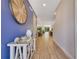 Inviting entryway with wood tile flooring, blue accent wall, and stylish decorative elements at 7647 Fairfax Dr, Kissimmee, FL 34747