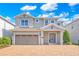Two-story home featuring a brick driveway and a two-car garage at 7647 Fairfax Dr, Kissimmee, FL 34747