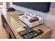 Close-up of a modern game console and remote controls on a glass shelf at 7647 Fairfax Dr, Kissimmee, FL 34747