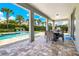 Covered patio with dining area overlooking the pool, perfect for outdoor entertaining at 7647 Fairfax Dr, Kissimmee, FL 34747