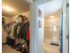 Walk-in closet transitioning to tiled bathroom featuring a glass-enclosed shower at 87 Delacorte Way, Oviedo, FL 32765