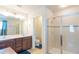 Bright bathroom with double sink vanity and glass enclosed shower with tiled floors at 87 Delacorte Way, Oviedo, FL 32765