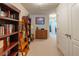 Hallway with built-in dark wood bookcase and storage leading to additional rooms at 87 Delacorte Way, Oviedo, FL 32765