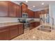 Well-equipped kitchen features granite counters, stainless steel appliances, and wood cabinets at 87 Delacorte Way, Oviedo, FL 32765