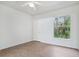 Minimalist bedroom with wood-look floors, a ceiling fan, and a window offering outdoor views at 8824 Villa View Cir # 204, Orlando, FL 32821