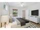 Bright bedroom featuring a ceiling fan, a dresser, and a view of wooded landscape at 8824 Villa View Cir # 204, Orlando, FL 32821