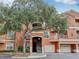 Condo building featuring covered parking and large shade tree at 8824 Villa View Cir # 204, Orlando, FL 32821