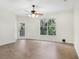 Bright living room with a ceiling fan, balcony access, and a large window offering beautiful green views at 8824 Villa View Cir # 204, Orlando, FL 32821