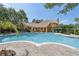 Large community pool with lounge chairs and a beautiful building in the background at 8824 Villa View Cir # 204, Orlando, FL 32821