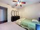 Cozy bedroom with green comforter, ceiling fan, three decorative mirrors, and black wood dresser at 920 Gloriosa Ave, Winter Park, FL 32789