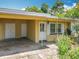 A clean carport with storage doors and access to the main entrance highlighted by mature landscaping and a number 920 at 920 Gloriosa Ave, Winter Park, FL 32789