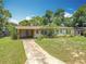 Charming single-story home with a brick walkway, yellow and white exterior, and mature landscaping in a suburban setting at 920 Gloriosa Ave, Winter Park, FL 32789