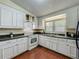 Classic white kitchen featuring wood floors, modern appliances, and good natural light at 920 Gloriosa Ave, Winter Park, FL 32789