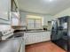 Well-lit kitchen area with a range, sink, and black refrigerator at 920 Gloriosa Ave, Winter Park, FL 32789