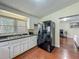 Functional kitchen area with sleek, black appliances and sink with view to the living room at 920 Gloriosa Ave, Winter Park, FL 32789